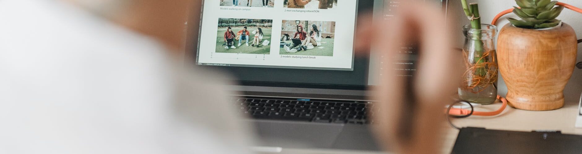 woman sitting at table with laptop and editing photos