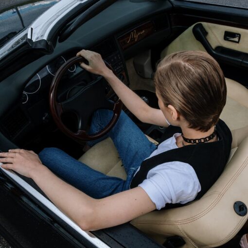 a woman driving a convertible car