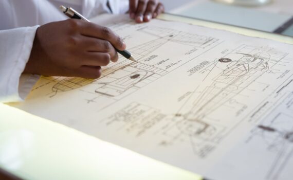 faceless engineer adding details to sketch of aircraft