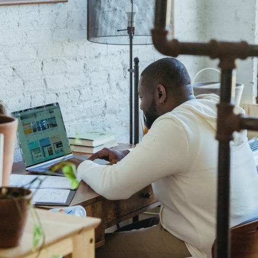 focused black man typing on laptop during remote work