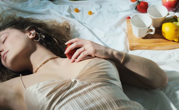 relaxed woman with fruit lying on blanket