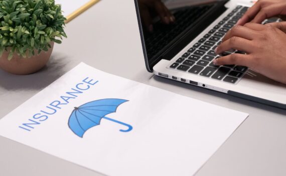 a paper beside a person typing on a laptop