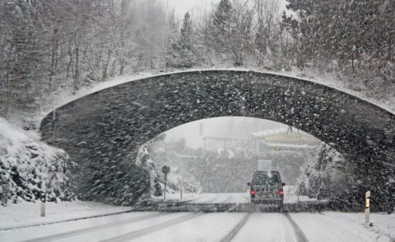 photo of white vehicle crossing a tunnel