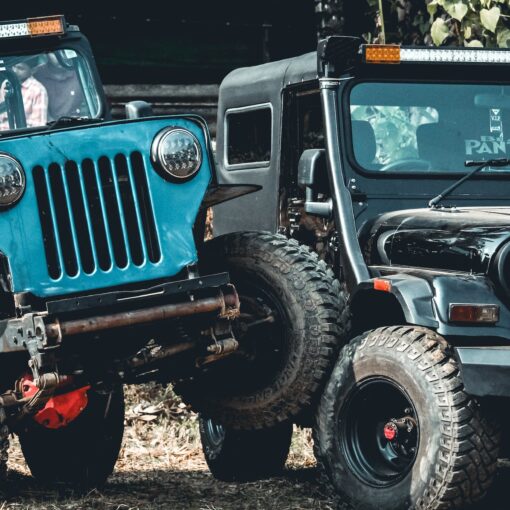 suv cars riding along dusty road during competition in countryside