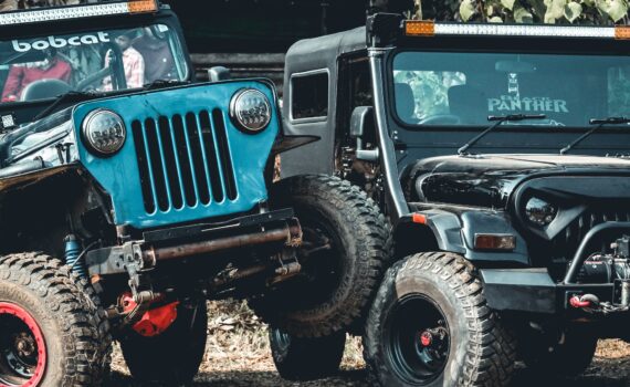 suv cars riding along dusty road during competition in countryside