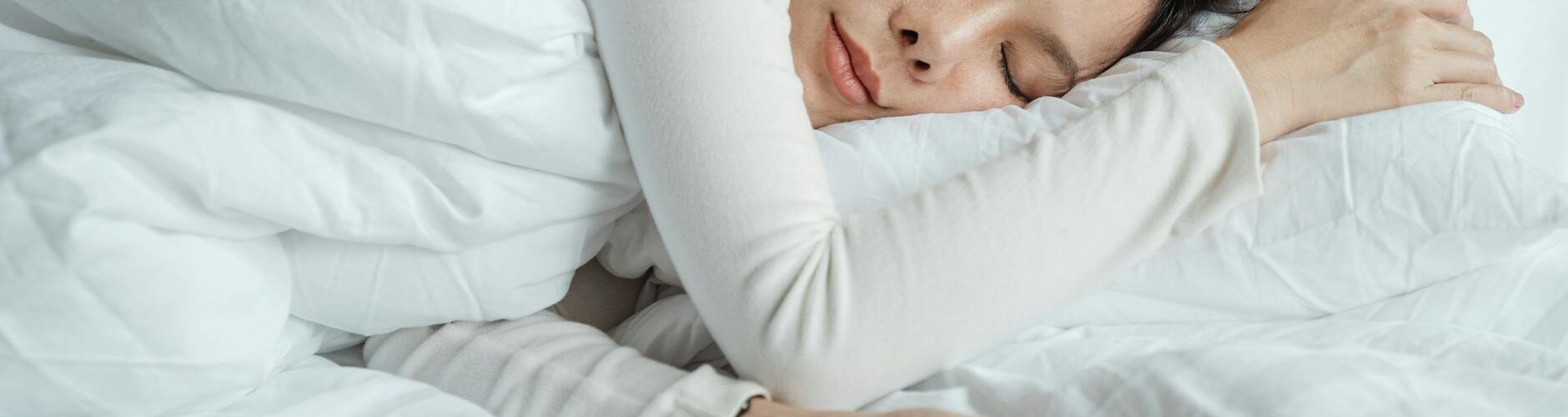 woman sleeping in bed near smartphone