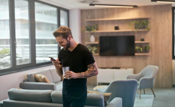 man in black shirt standing while holding drinking glass