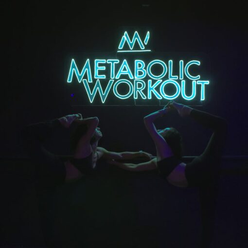 two women stretching under illuminated neon
