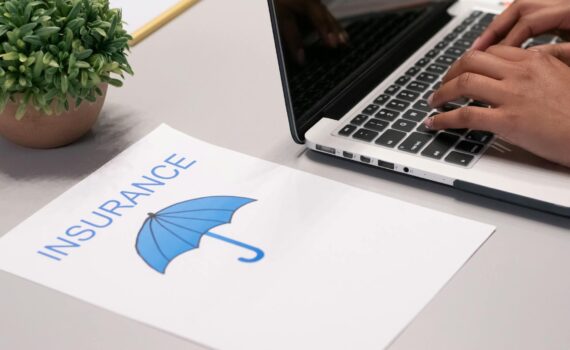 a paper beside a person typing on a laptop